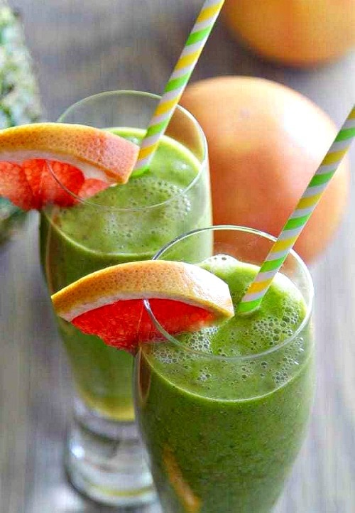 Tall glasses with Pink Grapefruit Green Detox Smoothies with grapefruit wedge and straw.