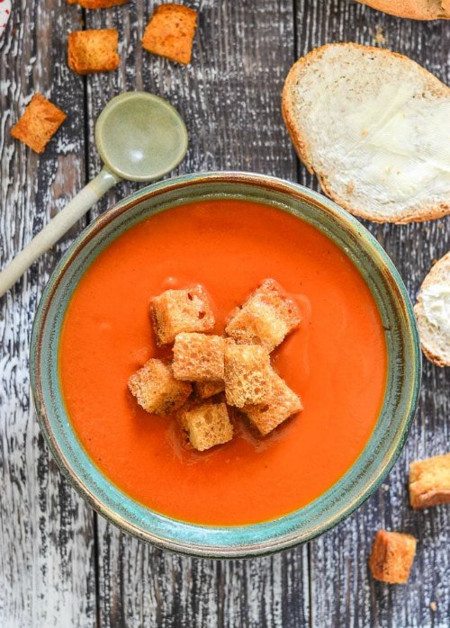 Overhead view of a bowl of  Instant Pot Tomato Soup with croutons.