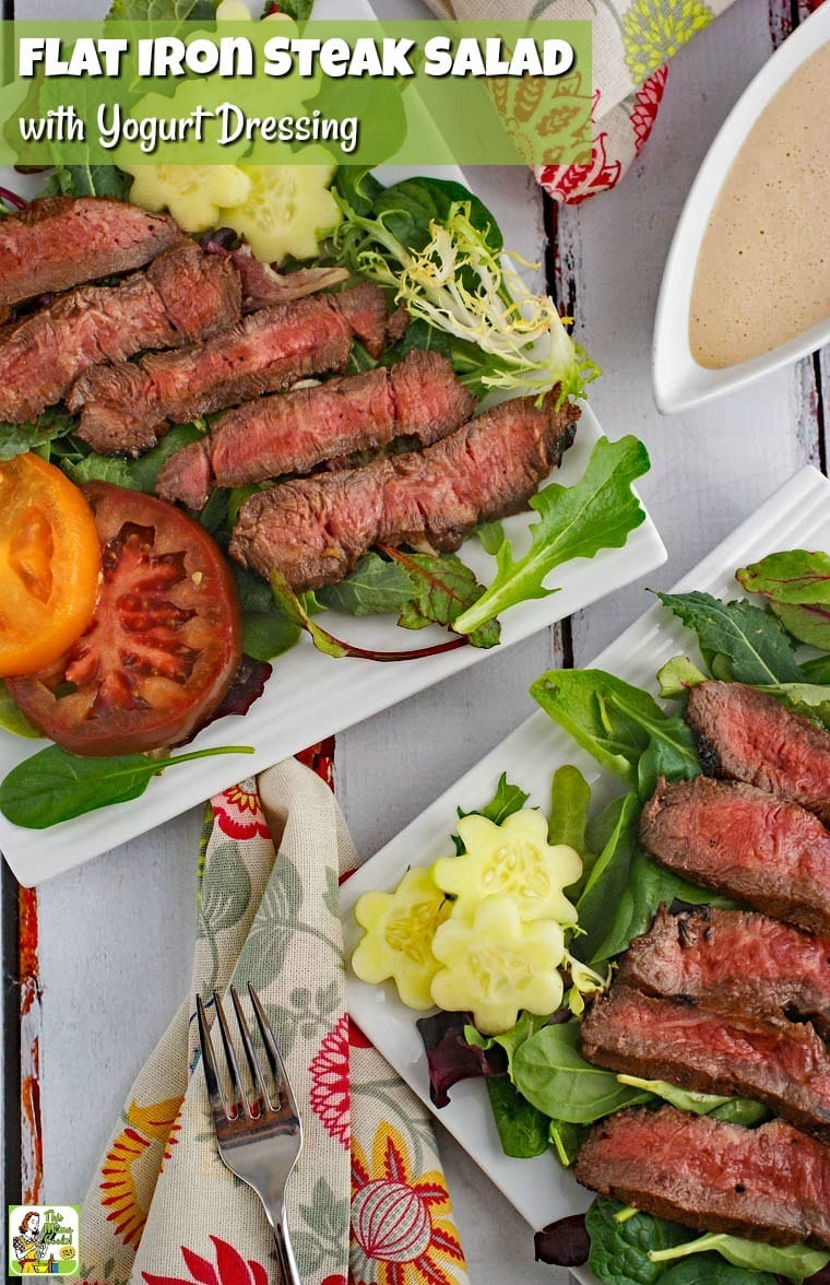 Closeup of plates of Flat Iron Steak Salad with Yogurt Dressing with salad and tomatoes with fork, napkin, and pitcher of dressing.