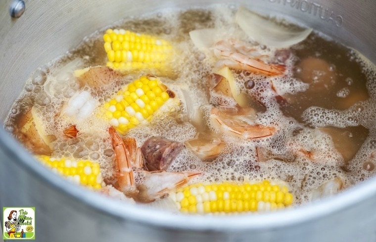 A pot of Cajun Seafood Boil with corn, potatoes, shrimp, and onions.
