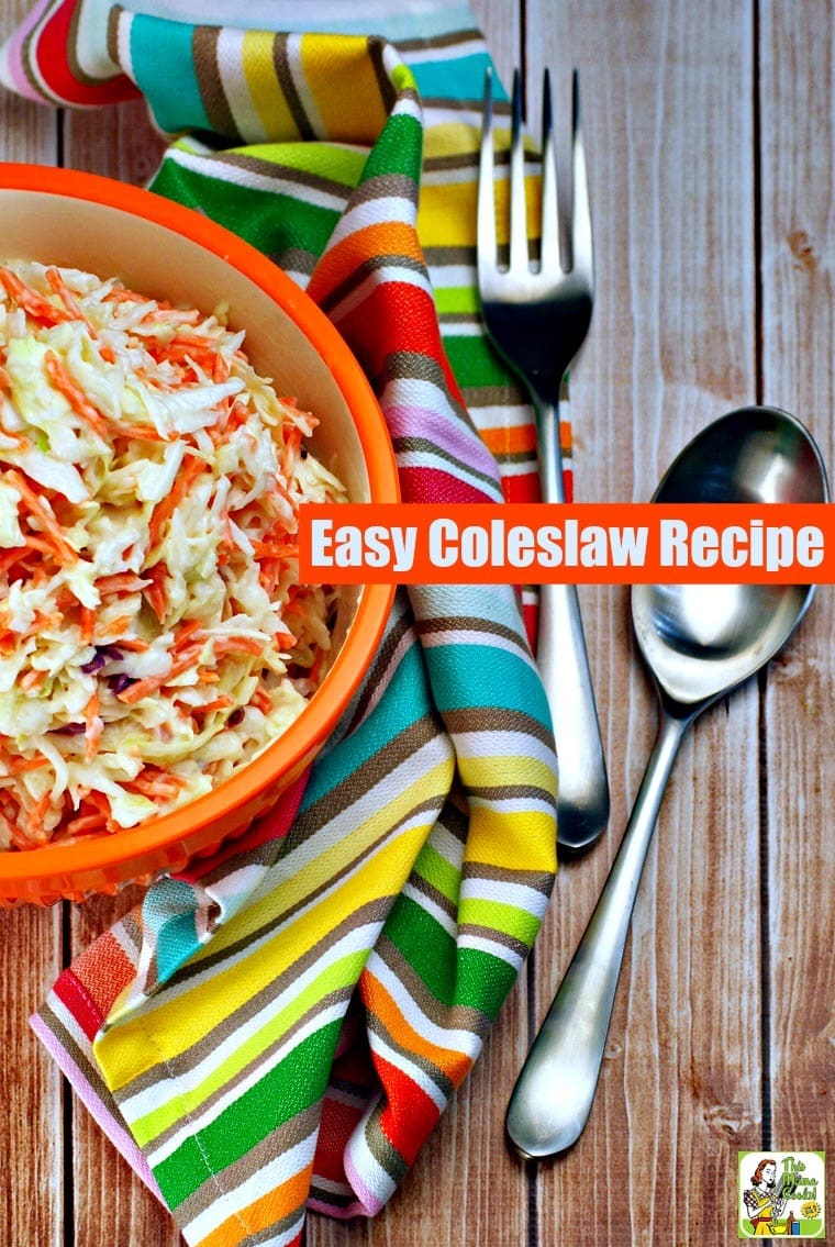 A bowl of coleslaw with striped towel and serving utensils.