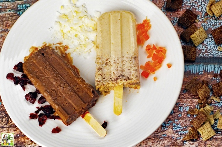 Two Homemade Ice Cream Bars on a plate with dried fruit, cereal, and coconut.