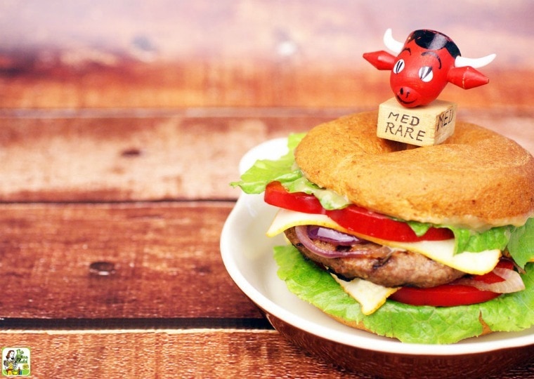 Bagel Burger with Miso Sauce with lettuce, cheese, onions, and lettuce on a plate.