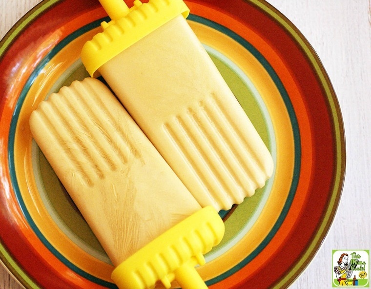 Two Greek Yogurt Popsicles on a multi-colored striped plate.