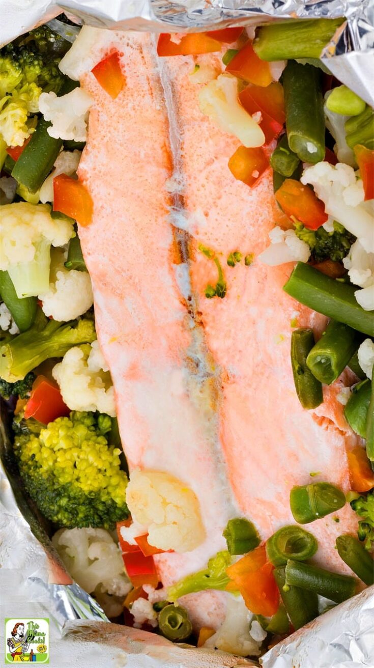 Grilled salmon in a foil packet with mixed roasted vegetables.