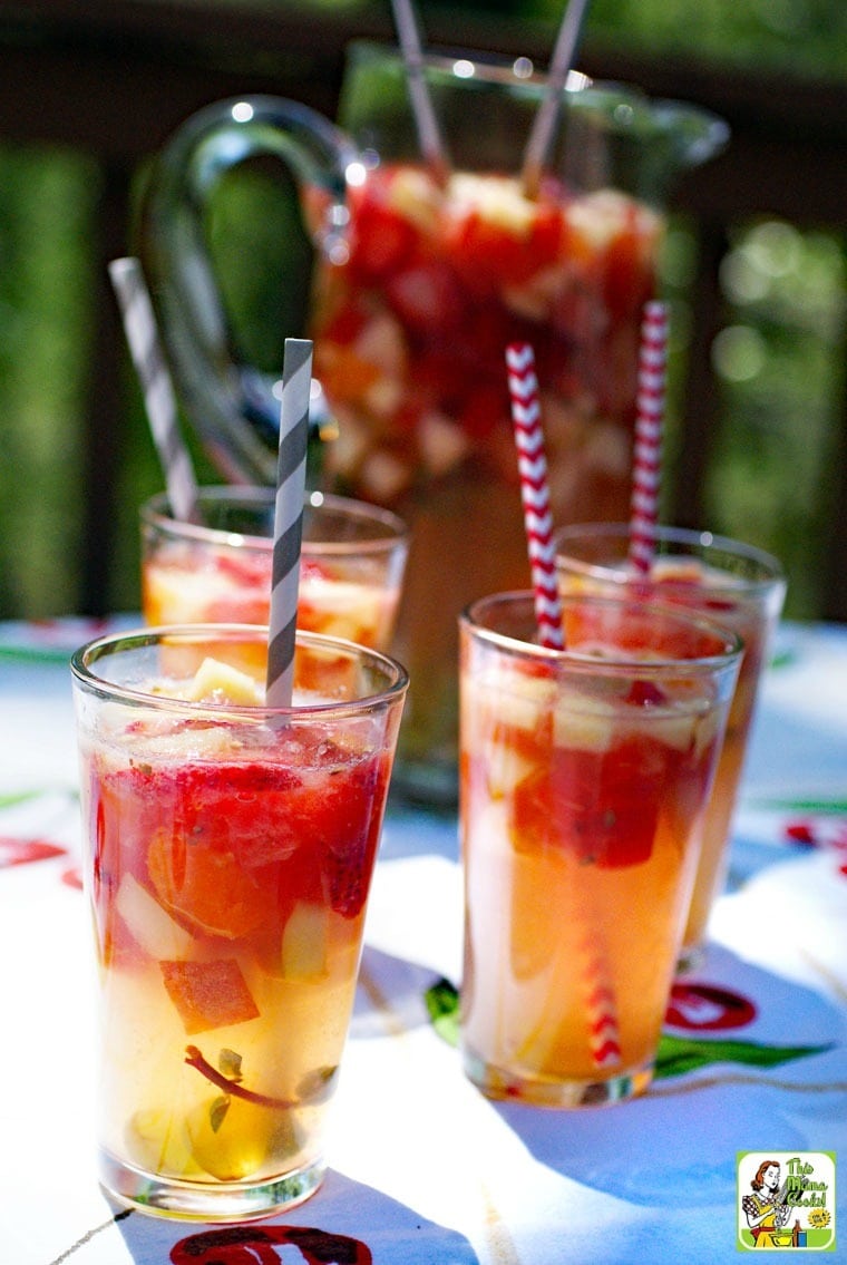 Glasses of Lemonade Sangria with striped straws on a colorful tablecloth.