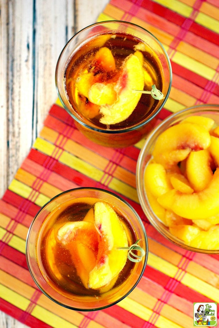 3 cocktail glasses of Peach Whiskey on a multi-colored placemat