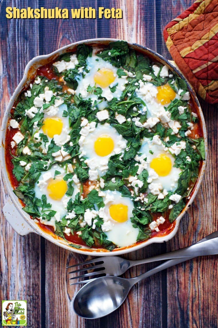 Overhead view of shakshuka with feta in a yellow skillet with rust-colored potholder.