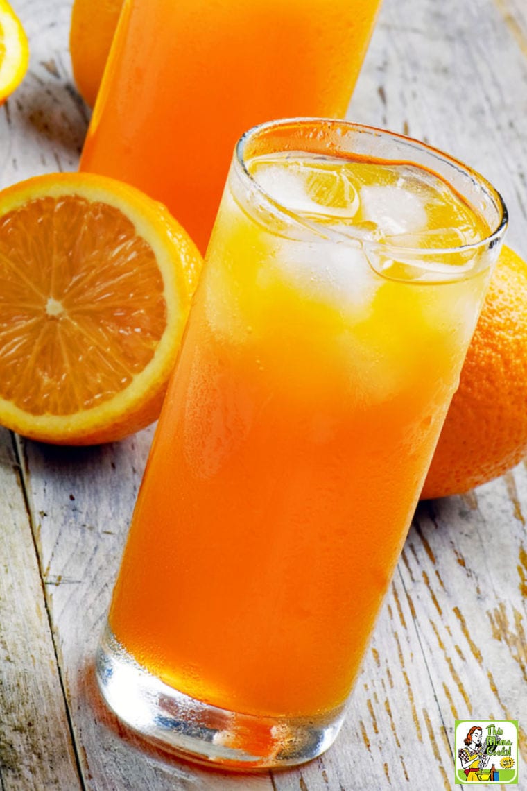 A glass of an orange drink with oranges 