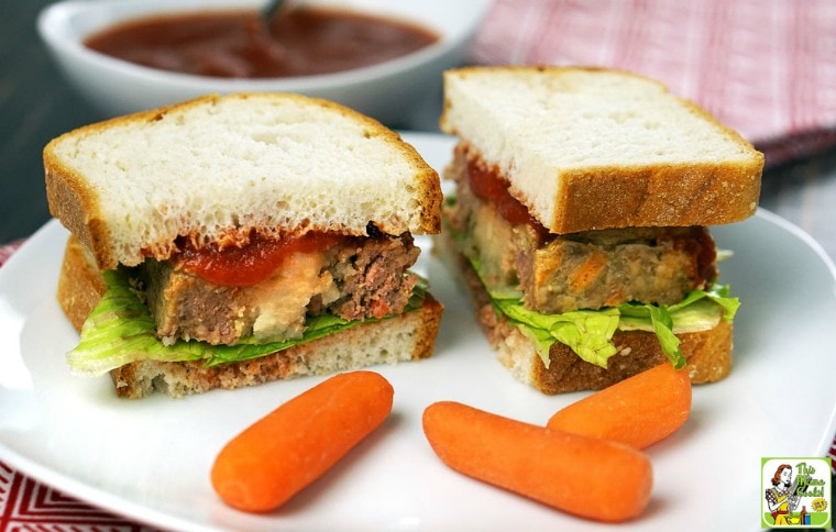 A plate with a Mashed Potato Stuffed Meatloaf sandwich with baby carrots.