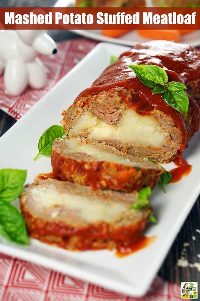 Platter with a mashed potato stuffed meatloaf covered in ketchup.