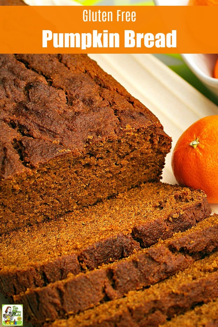Closeup of a  loaf of  Pumpkin Bread sliced up on a white plate with an orange.