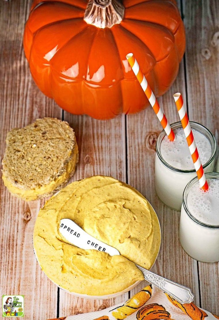 Pumpkin dip in bowl with sandwich and milk.
