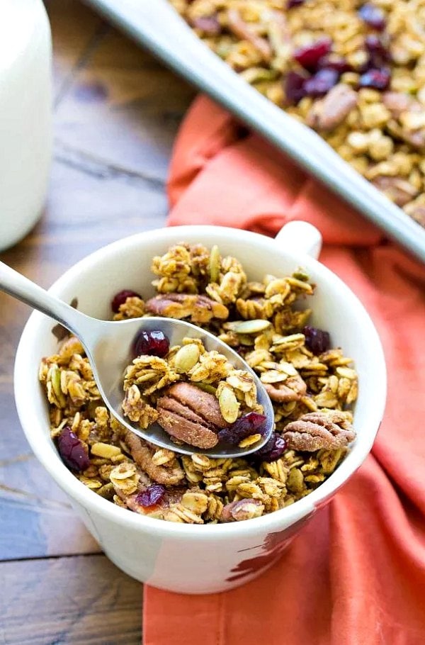 A bowl and spoon of pumpkin spice granola.