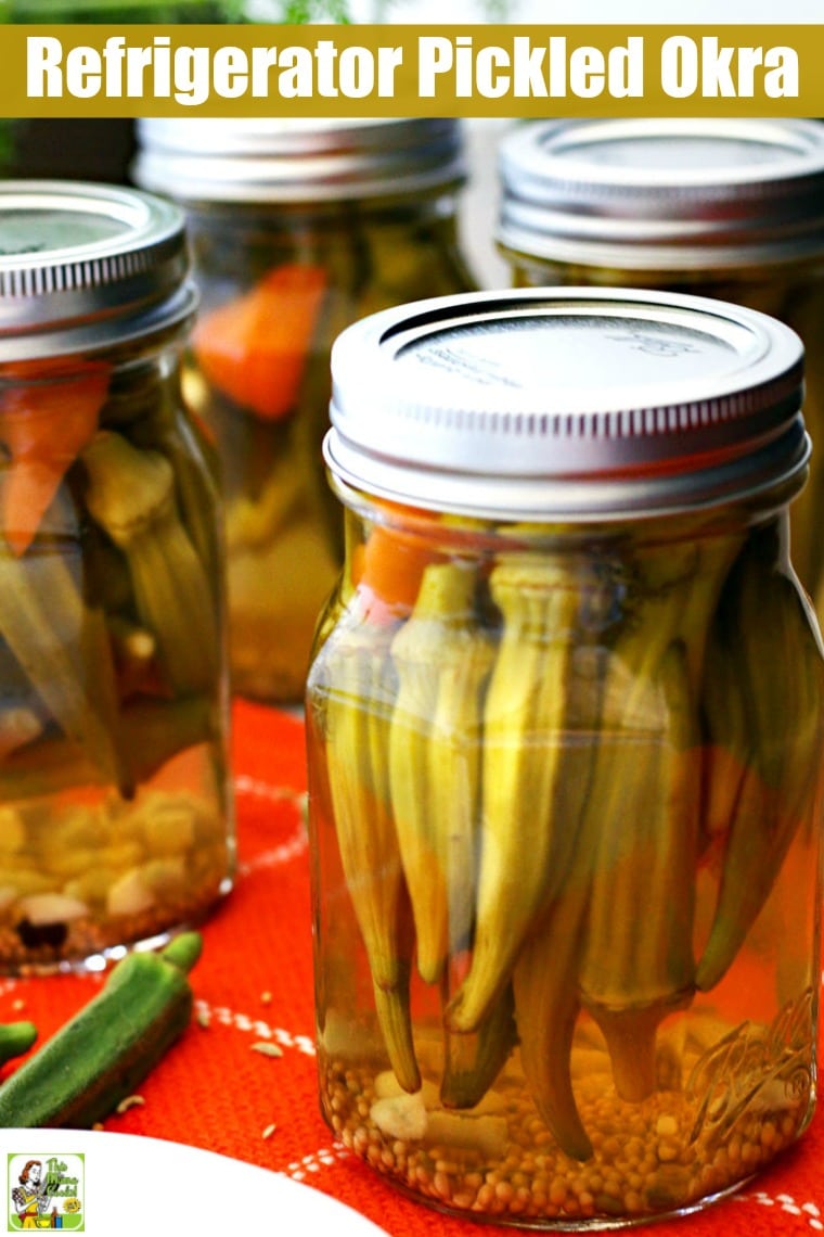Mason jars of pickled okra on an orange napkin.