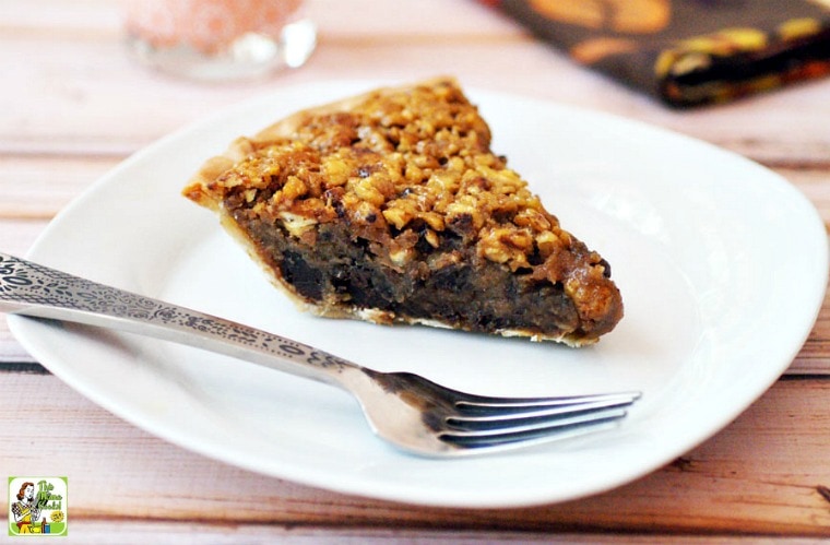 A slice of Gluten Free Chocolate Pecan Pie on a white plate with a silver fork. 