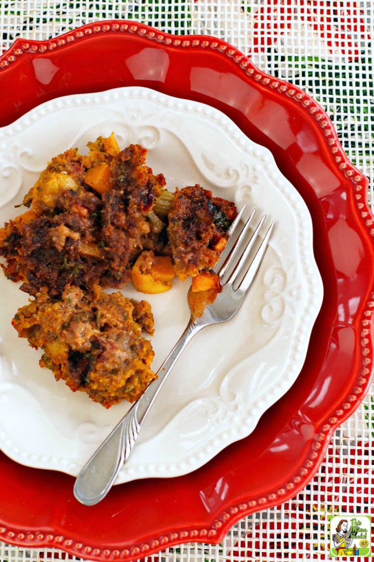 Thanksgiving stuffing with chorizo and squash on white and red plates with a fork.
