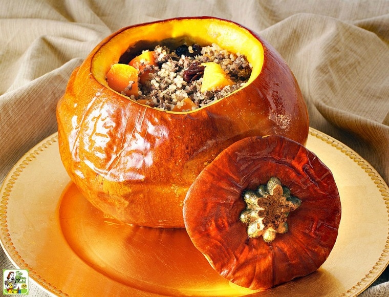 Baked Stuffed Pumpkin stuffed with quinoa, venison, dried cherries, and butternut squash, on a golden platter.