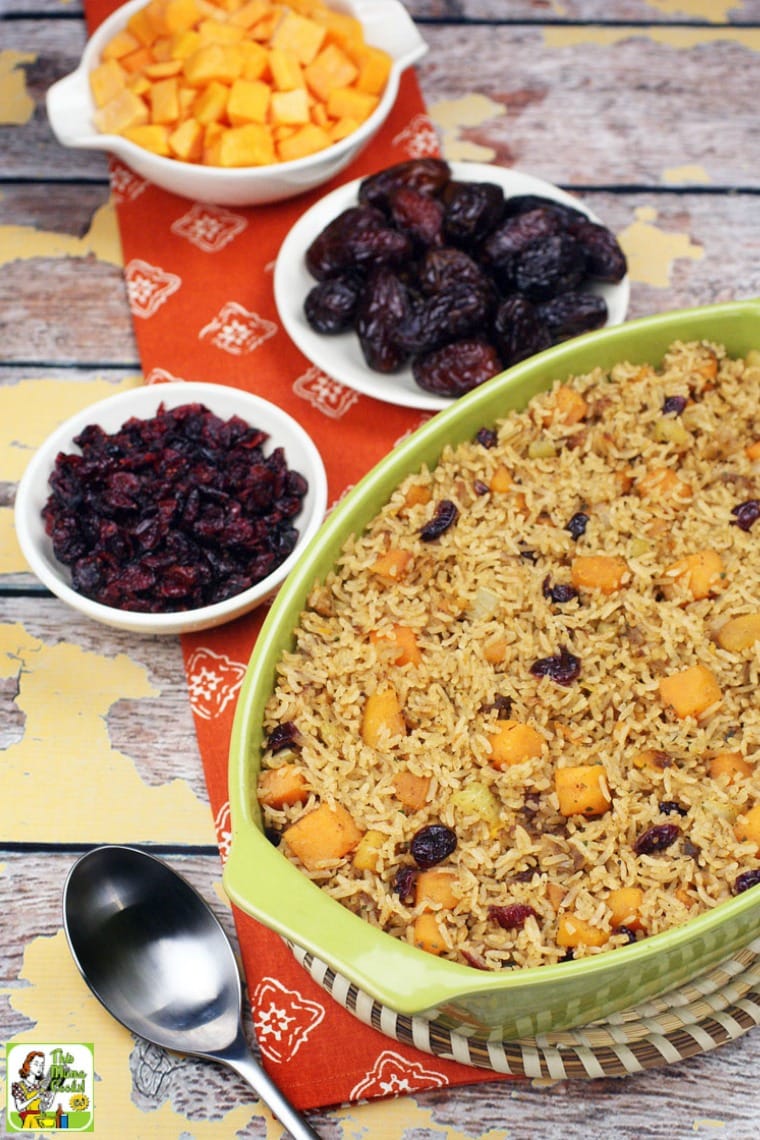 A casserole dish of rice stuffing with bowls of cranberries, squash and dates.