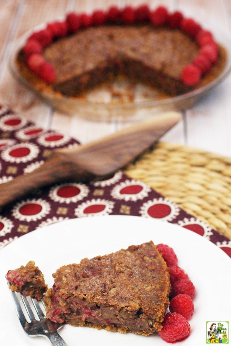 A slice of gluten free pecan pie with no corn syrup on a white plate with a fork.