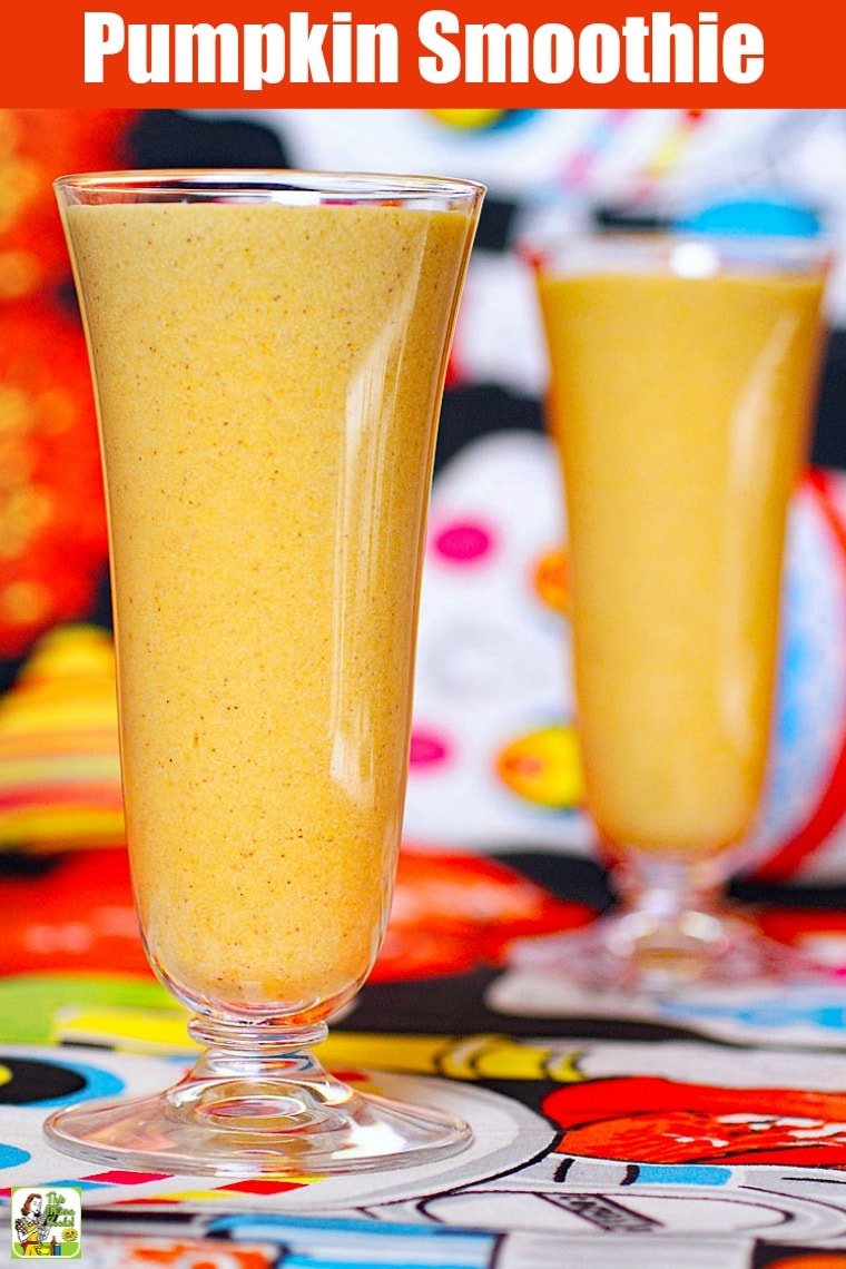 Two tall glasses of Pumpkin Smoothie on a day of the dead tablecloth. 