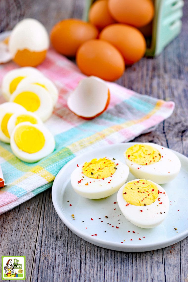 Sliced hard boiled eggs on a white plate and plaid napkin.