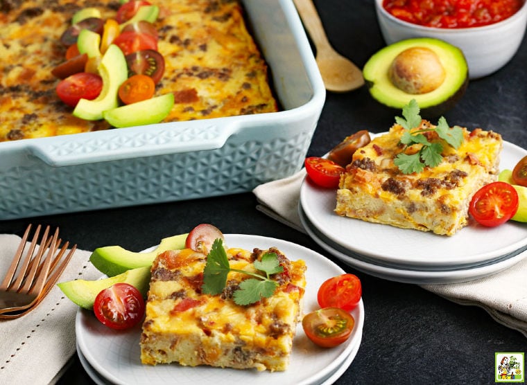 Plates and casserole dish of Overnight Breakfast Casserole with napkins, forks, and serving spoon.