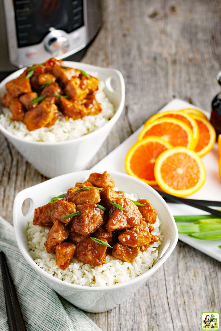 Two bowls of Instant Pot Orange Chicken on white rice.