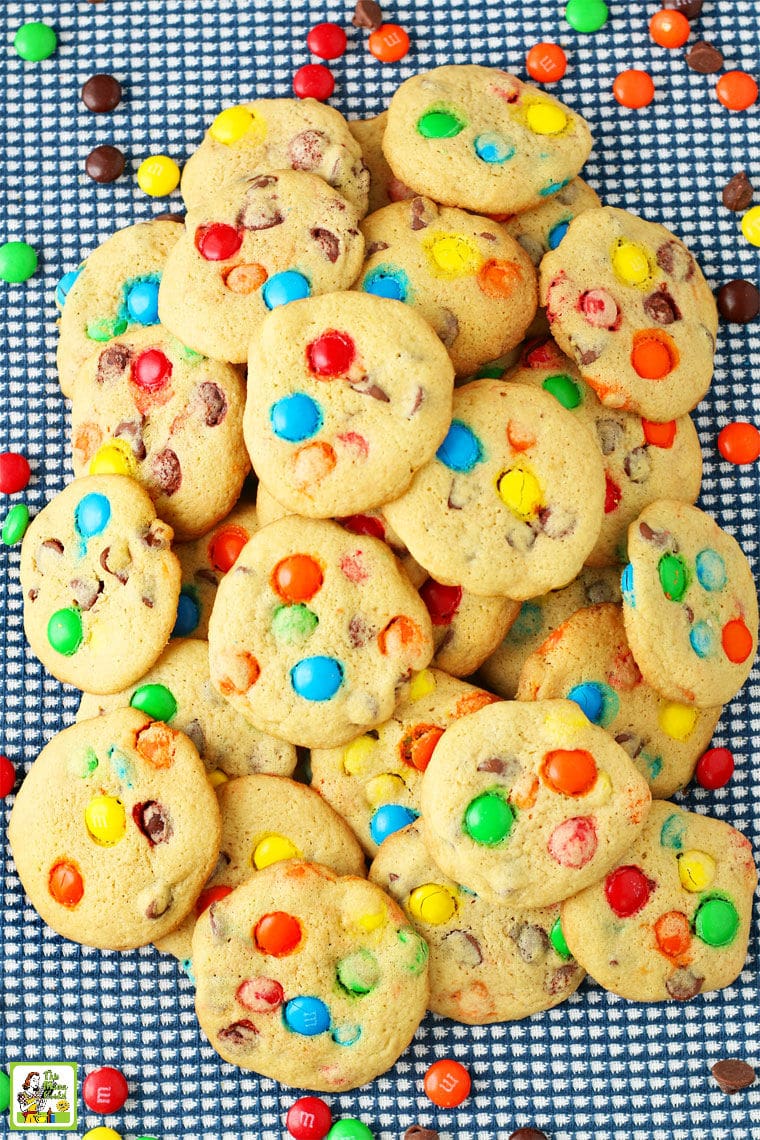 A pile of M&M Chocolate Chip Cookies on a blue and white tea towel