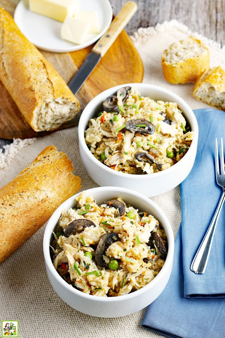 Bowls of Chicken and Rice with a blue napkin, forks, and French bread