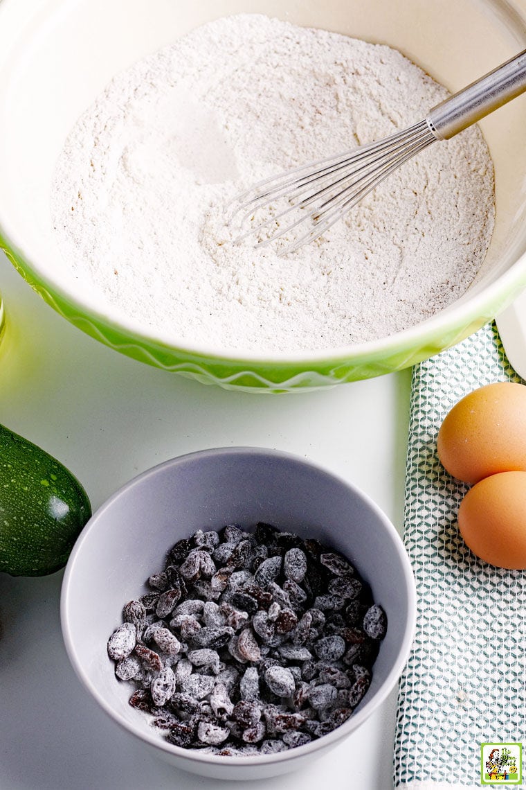 Ingredients for making zucchini muffins in a bowl with whisk