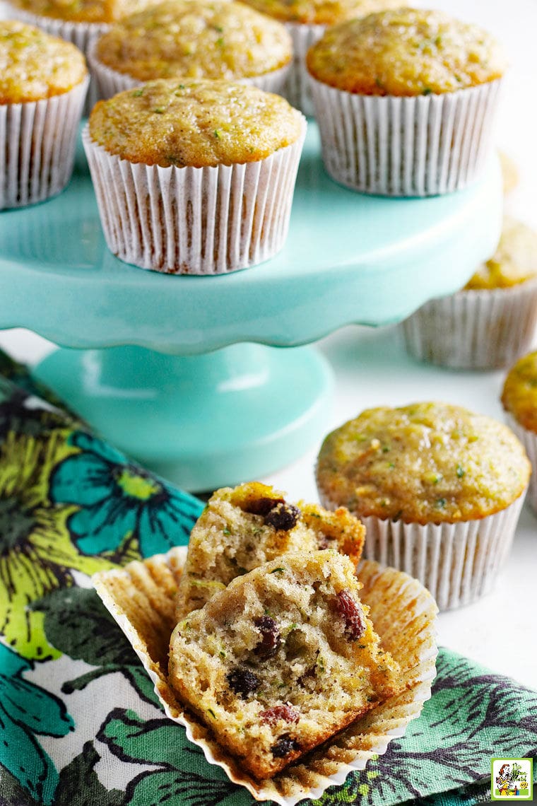 Close up of zucchini Muffins on a turquoise cake stand with a floral napkin.