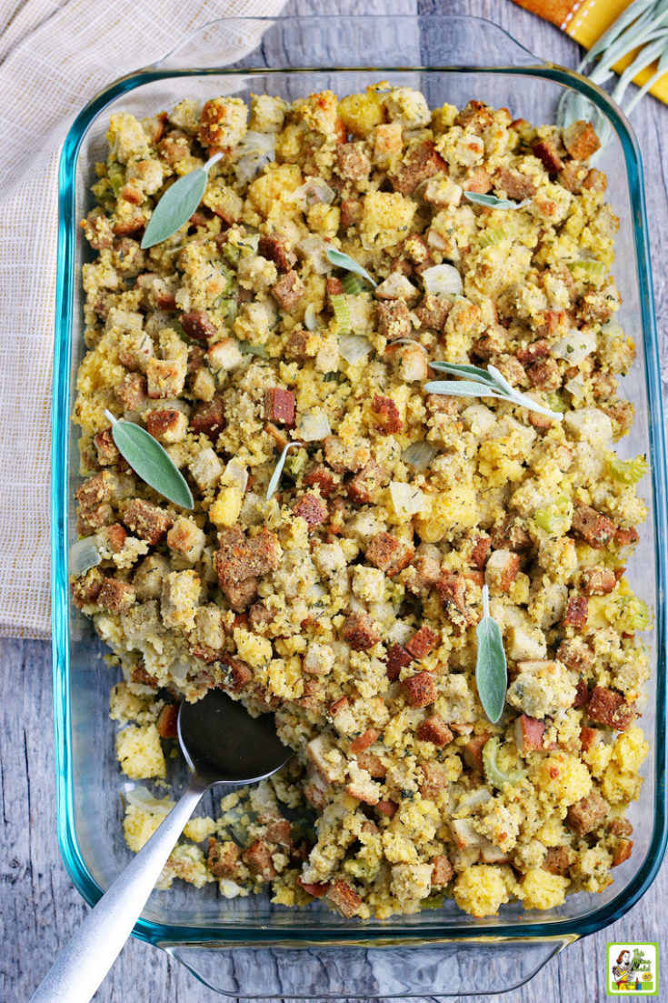A glass dish of Cornbread Stuffing with a servng spoon.