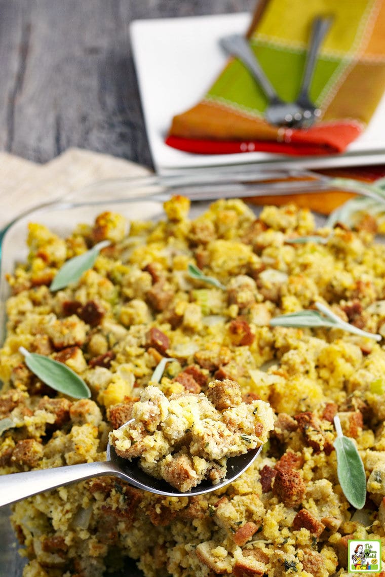 A serving spoon above a baking dish of Cornbread Stuffing. 