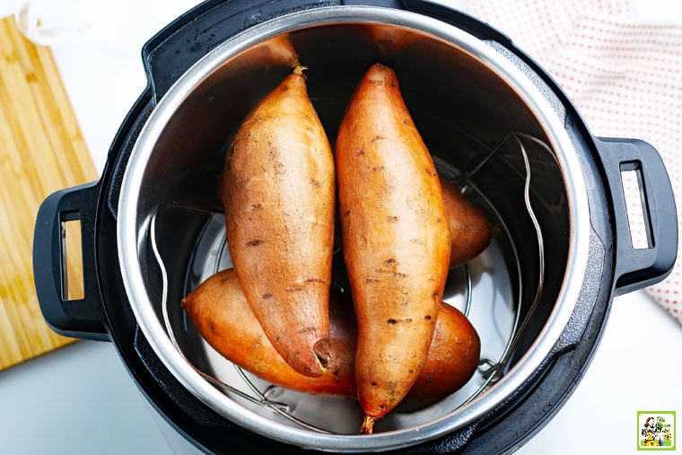 Sweet potatoes sitting on a trivet in a Instant Pot pressure cooker.