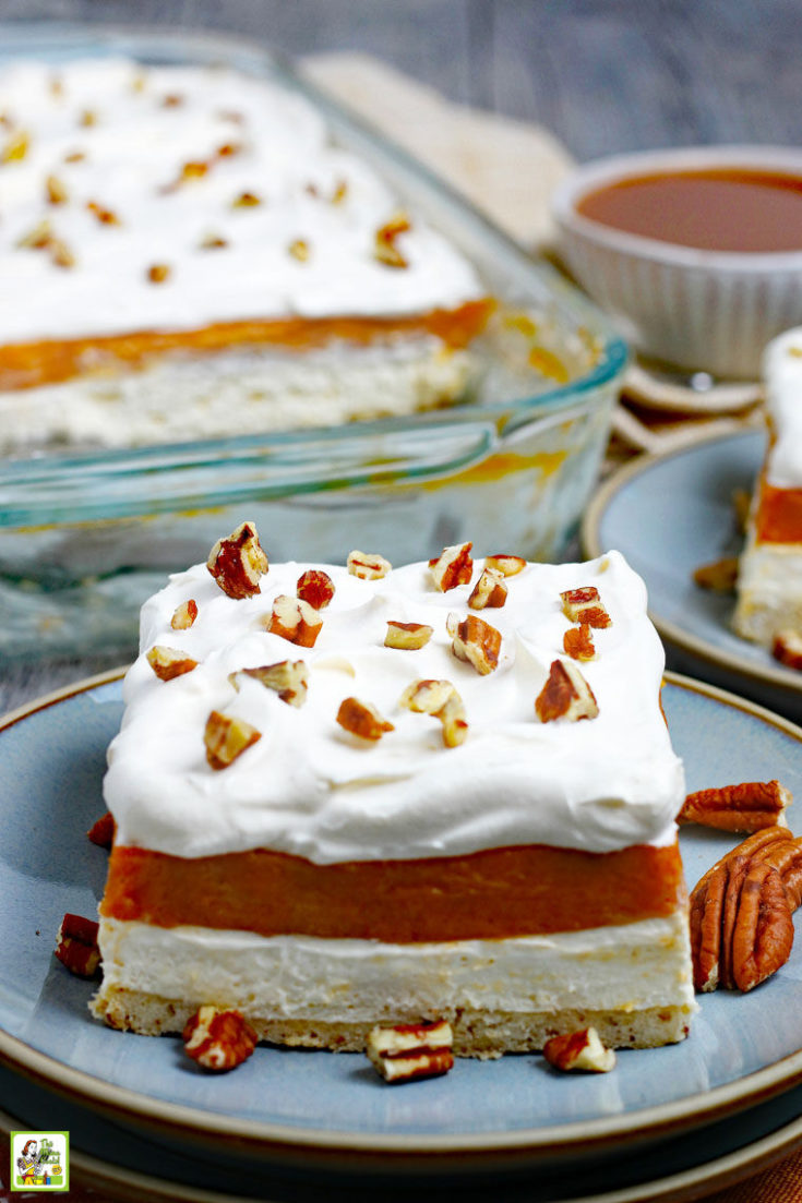 A large serving of Pumpkin Cheesecake Lasagna dessert on a blue plate with pecans.