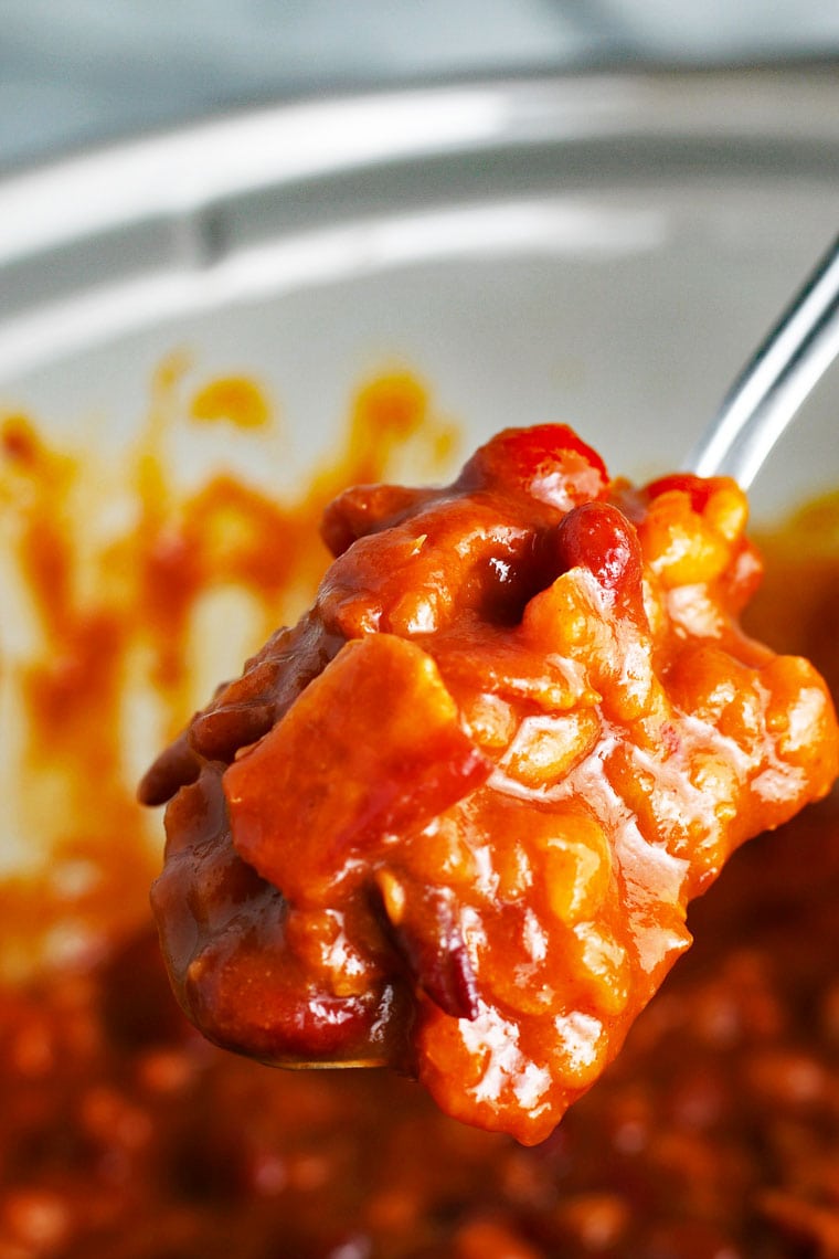 Spoonful of baked beans with bacon. 