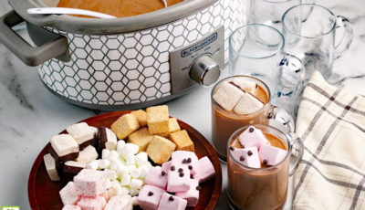 Crockpot Hot Chocolate made in a slow cooker served with marshmallows in glass mugs.