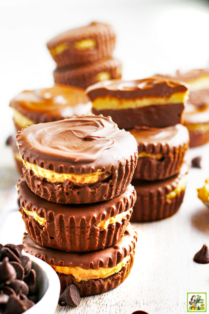 Closeup of stacks of homemade peanut butter cups with a spoon of peanut butter.