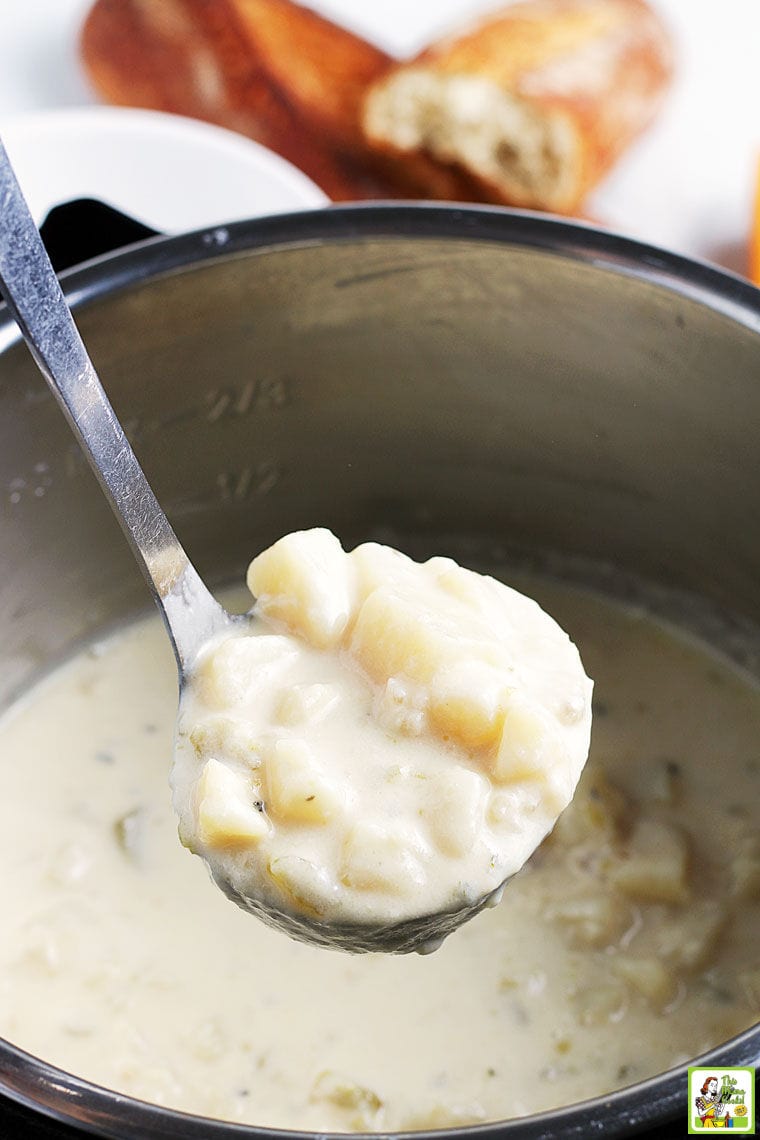 Closeup of a ladle of potato soup over a pot of soup.