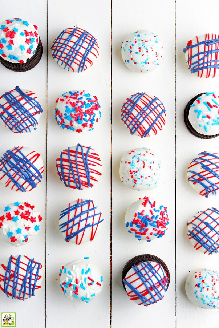 Individual red, white, and blue Oreo cake balls on a white board.