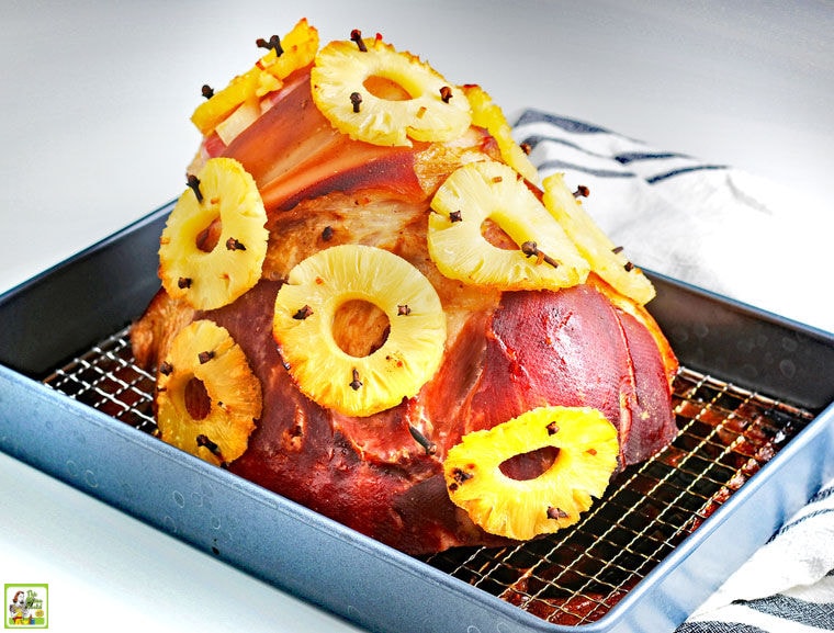 Spiral ham with cloves and pineapple rings in a baking pan.