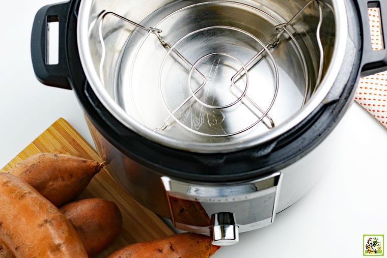 Empty Instant Pot with trivet and sweet potatoes.