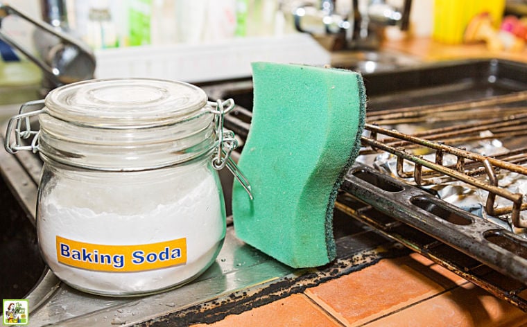 A jar of baking soda, a sponge, and oven racks.