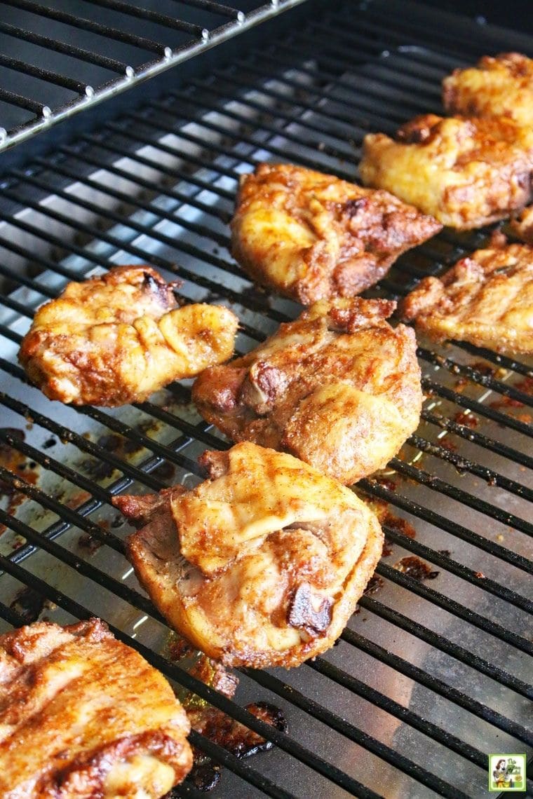 Chicken thighs cooking on a Traeger smoker grill.