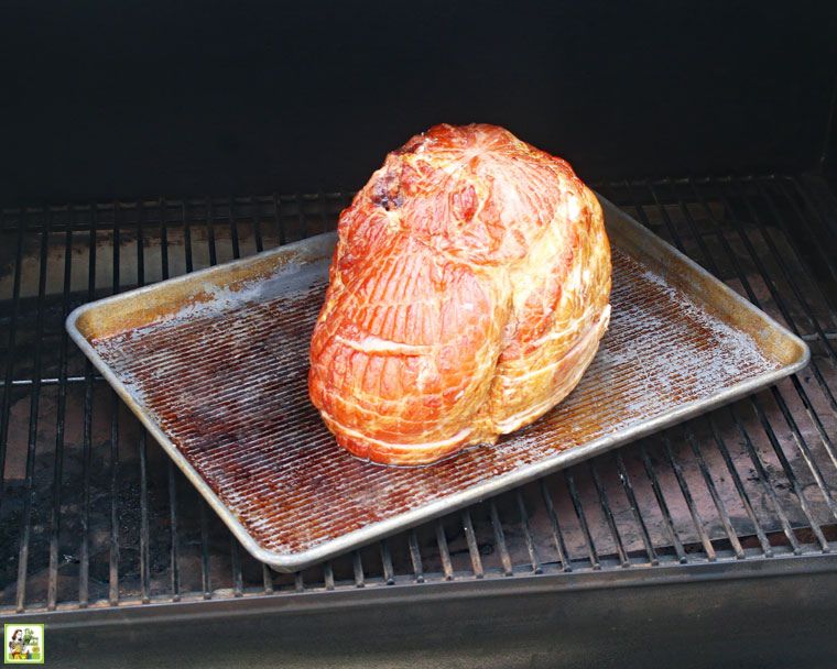 Cooking a spiral cut ham on a pan placed on a Traeger smoker pellet grill.