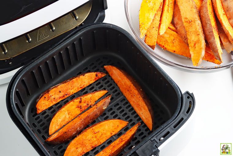 Sweet potato wedges cooked in an air fryer basket.